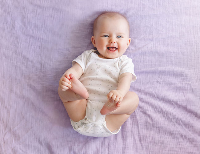 Newborn playing with feet.