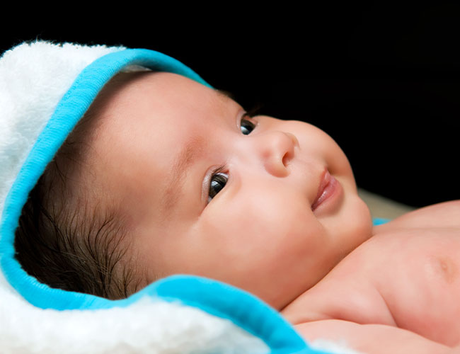 Newborn baby alert and smiling.